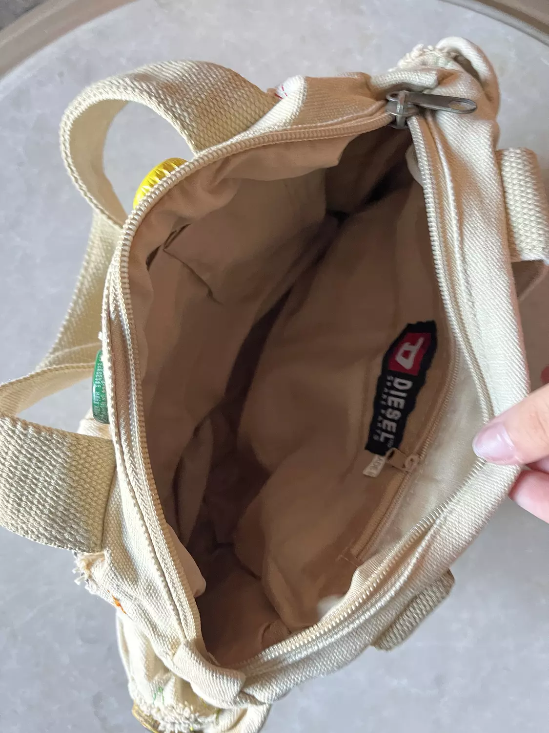 Beige ripped diesel bag with adjustable buttons  hover image