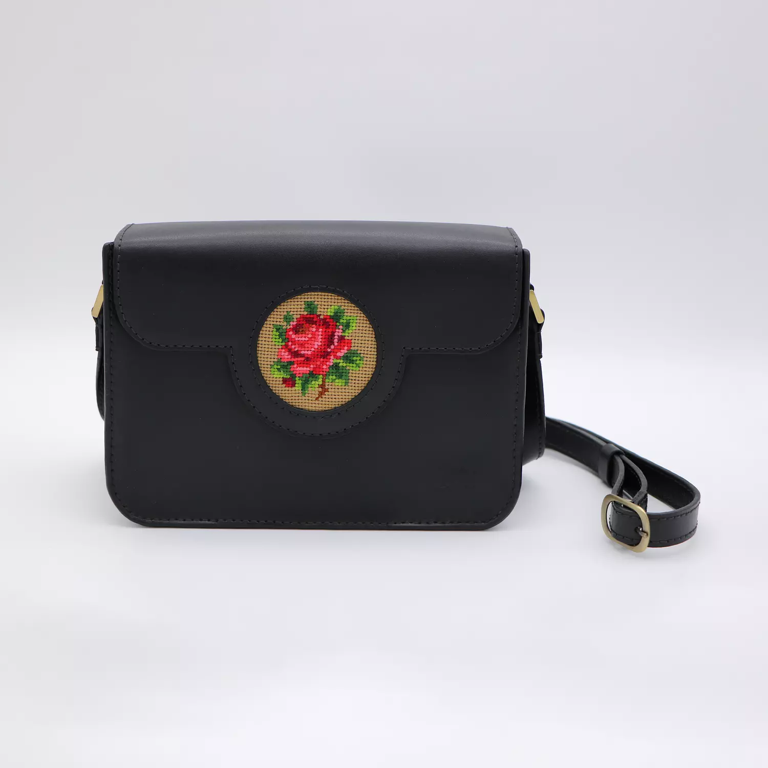 Black genuine leather bag with floral design. image